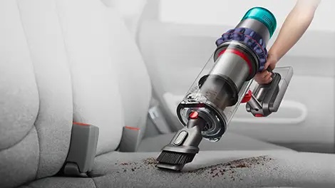 Combination Tool being used to clean the upholstery of a car seat.