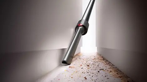 Crevice Tool cleaning out a narrow space between furniture.