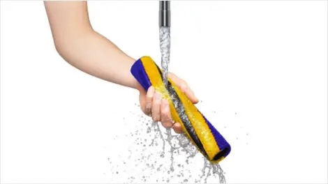 Washing a Fluffy brush bar under a running tap.